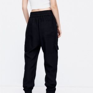 Women’s black Zara Cargo pocketed pants with elastic cuff bottoms. Size Large